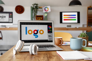 Graphic designer's workplace with laptop in office, closeup