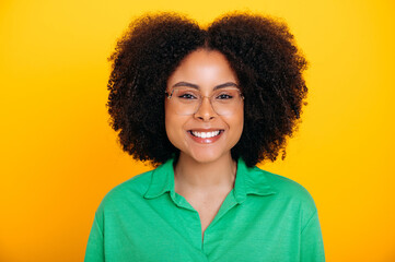 Close-up photo of a pretty, positive curly young woman of brazilian or african american ethnicity,...
