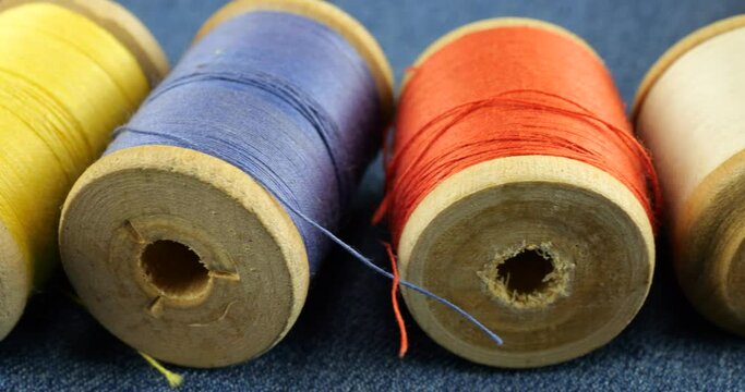 Vintage wooden spools with cotton threads in different colors.