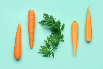 Fresh carrots and slices on turquoise background