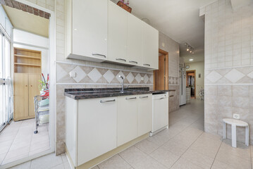 Spacious kitchen with cabinets on both sides of the walls, polished granite countertops