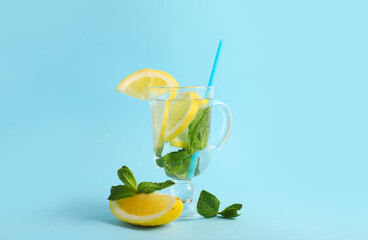 Glass of infused water with lemon and mint on blue background
