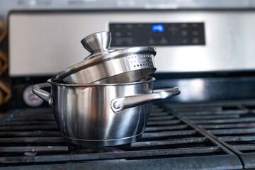 Steel saucepan with a glass lid on a gas stove.