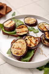 Toasts with delicious grilled eggplants on light background