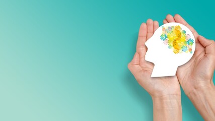 Hands holding human head model with brain