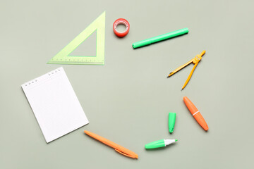 Open notebook with different stationery on grey background