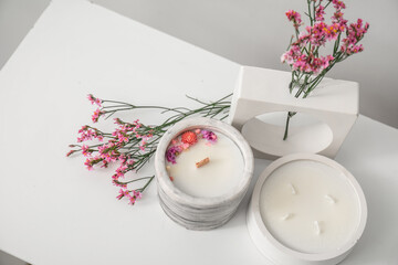Beautiful flowers and candles on table in room, closeup