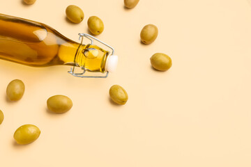 Bottle of fresh olive oil on beige background
