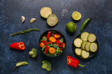 Obraz na płótnie Canvas Bowl with fresh vegetables on blue background