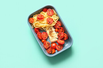 Baking dish of tasty pasta with tomatoes and feta cheese on turquoise background