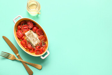 Baking dish with tasty tomatoes and feta cheese on turquoise background