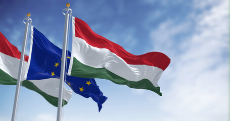 The flags of Hungary and the European Union fluttering together on a clear day