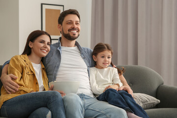 Obraz premium Happy family watching TV on sofa at home