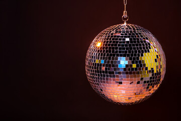 Shiny bright disco ball on dark background, space for text