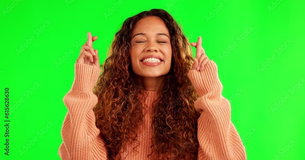 Wall mural Happy, fingers crossed and a woman with a wish or hope on green screen thinking of dream. Latino model person with hand sign or emoji while praying for good luck for lottery on a studio background