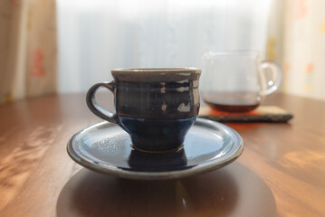 陶器のコーヒーカップとコーヒーが入ったガラス製のサーバー