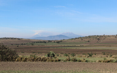 Fototapeta na wymiar Paisaje de campo con volcanes de fondo. 