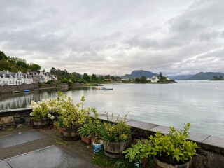 A view of the beautiful  small Scottish highlands town of Plockton, with flowers along the road, along the waters of Loch Carron,in  Scotland, United Kingdom