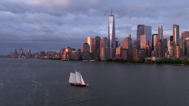 Dramatic Aerial Shot of Sailboat and NYC skyline at sunset