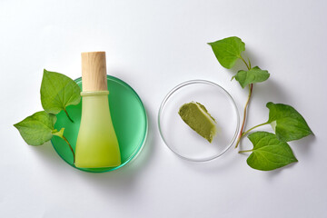 Mockup scene for advertising product with green bottle unbranded on petri dish with green liquid and fish mint and a cream texture on transparent podium. Blank space for design