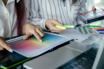 graphic designer working with laptop and color swatch. creative man using digital tablet at modern office.