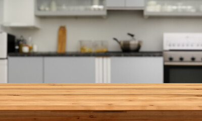 Wooden counter with blurred kitchen background. Table in the foreground for displaying products.