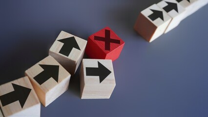 Wooden blocks with arrow and error icon. Delays and disruptions, stop the process, critical error...