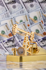 A coin of 1 riyal of the Kingdom of Saudi Arabia and a golden oil pump against the background of...