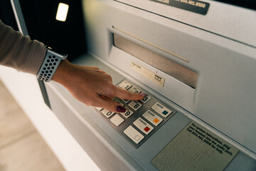 girl presses the buttons at the ATM