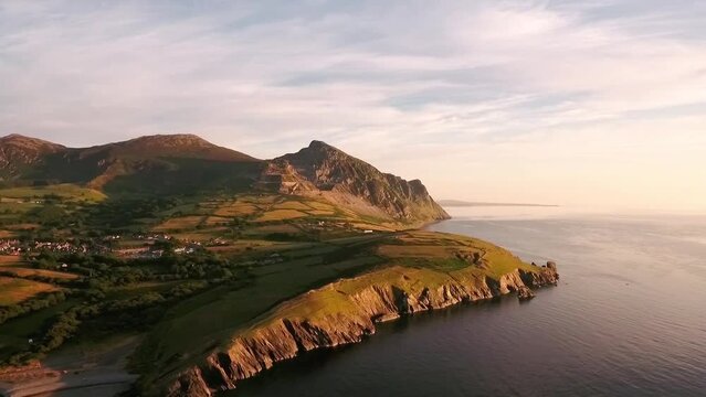 Aerial view right to left of Mountain range Yr Eifl at Trefor with granite quarry and view of Trefor Village with blue skies on a summers day across the Irish Sea on the Llyn Peninsula in North Wales