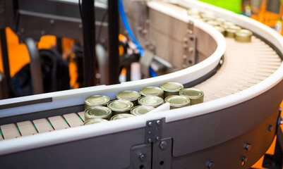 Food canned factory. Food tin cans on belt conveyor. Food industry.