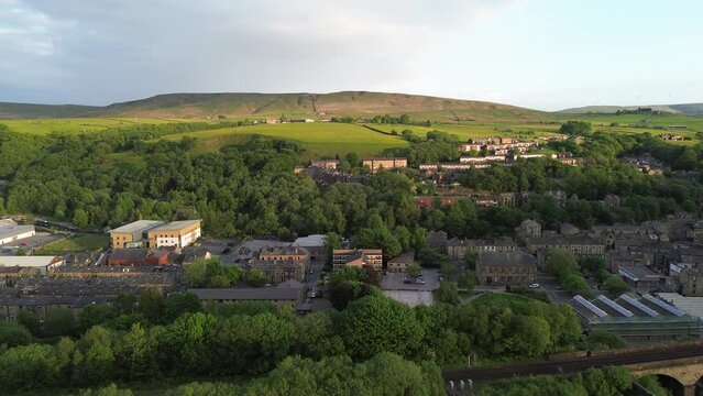 short fly over todmorden town center showcasing tree tops and old rural buildings 