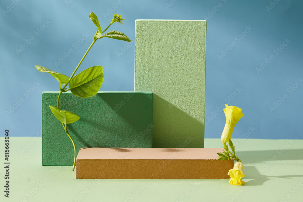 Sticker Minimal empty display product presentation scene with rectangular podiums, yellow flowers and green leaf decorated on blue background with shadow leaf. Front view, advertising photo