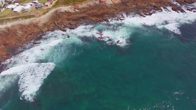 South Africa Still Bay Bae beach aerial drone cinematic beach small surf town beach reef Garden Route Jeffreys Bay waves crashing aqua blue green ocean late morning afternoon pan down forward movement