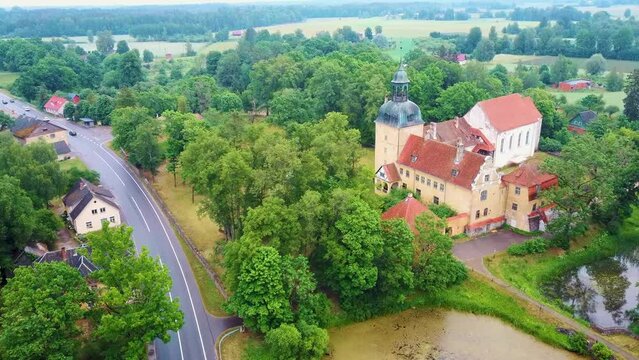 Lielstraupe Medieval Castle in the Village of Straupe in Vidzeme, in Northern Latvia. Aerial Dron Shot Lielstraupe Castle United in One Corps With the Church Surrounded by a Park With Pond. Rainy Day