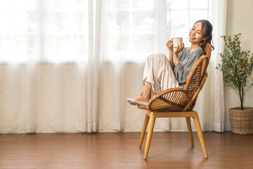 Portrait of smiling happy cheerful beauty pretty asian woman relaxing drinking and looking at cup of hot coffee or tea.Girl felling enjoy having breakfast in holiday morning vacation at home