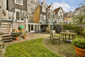 a backyard area with tables and chairs, including an outdoor dining set on the grass in front of the house