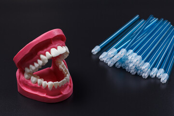 Human jaw layout with saliva ejectors on the black background.