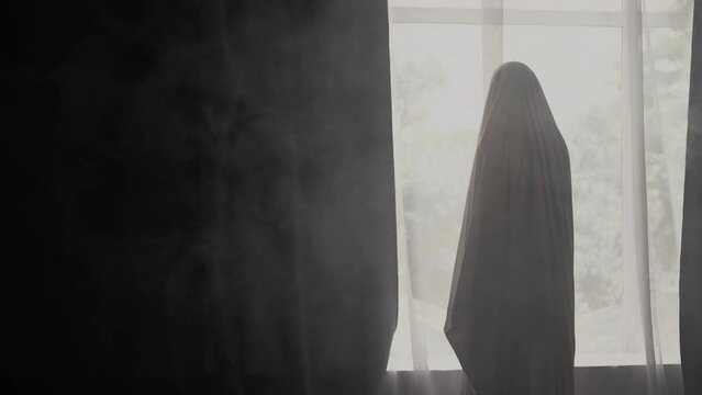 Ghost in the room standing near the window. Halloween concept