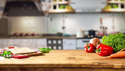 Empty wooden table with fresh vegetables and spices and cook on the background blurred kitchen,...
