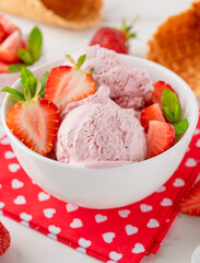 Strawberry ice cream with fresh berries in a bowl on a white wooden background. Selective focus