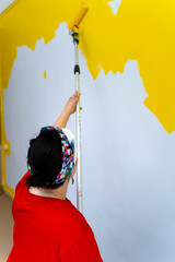 Painting Home Interior: Woman Creates a Sunny Atmosphere with Yellow