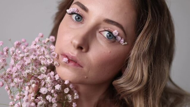 Portrait of a beautiful blondie woman with perfect skin and creative floral makeup look. Gypsophila eye makeup. The concept of cosmetic procedures, femininity, congratulations on women's day.