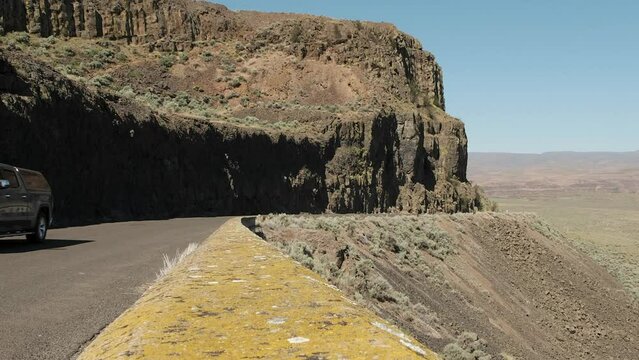 Truck drives cliff road in rugged Frenchman Coulee in WA Scablands