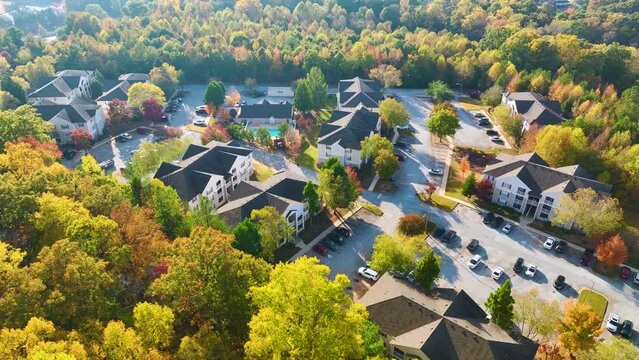 Aerial view of new apartment houses between yellow trees in South Carolina suburban area in fall season. Real estate development in american suburbs