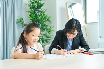 Obraz premium 勉強する女の子とサポートするスーツ姿の女性
