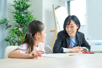 Obraz premium 勉強する女の子とサポートするスーツ姿の女性