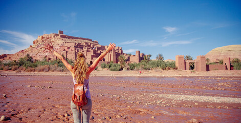Happy woman tourist enjoying view of Ait Ben Haddou Kasbah in Morocco - obrazy, fototapety, plakaty