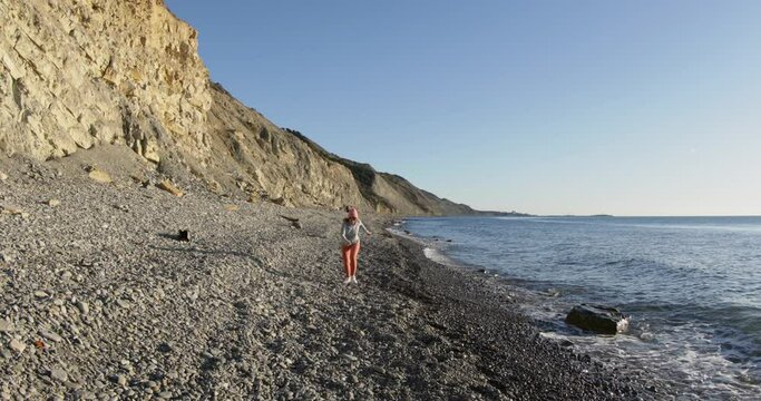 Woman running on coastline. Workout, training and wellness concept at sea beach.