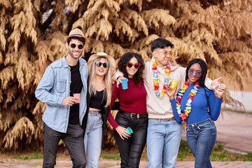 Fototapeta premium Happy group of multi-ethnic friends having fun while partying at an outdoor carnival. Party, carnival and friendship concept.